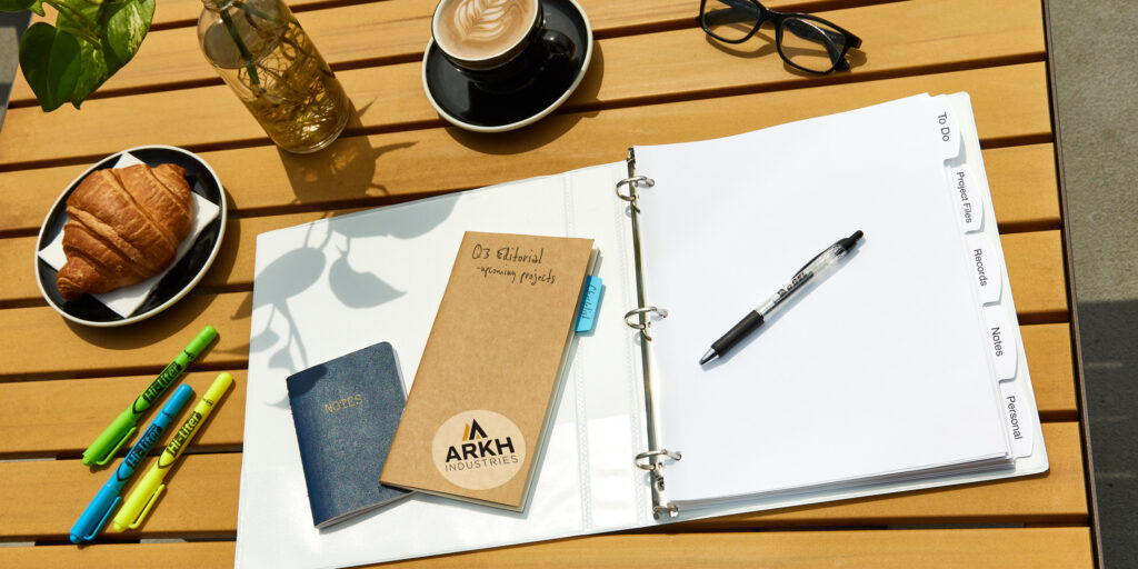 Outdoor wooden table with an open durable Avery binder showing Avery dividers used as a portable filing system for working remotely outdoors.