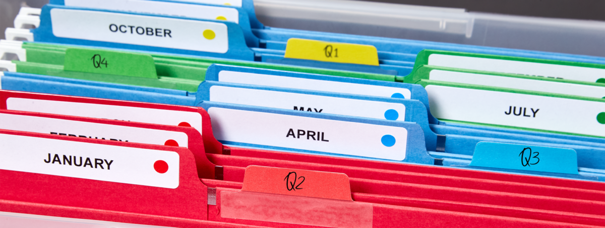 Color-coded file folders organized by month and quarters using custom-printed Avery file folder labels.